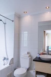 a white bathroom with a toilet and a sink at Apart Hotel Colors in La Serena