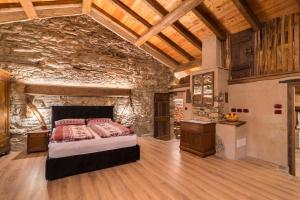 a bedroom with a bed and a stone wall at La Mason dla Grà in Frassinetto