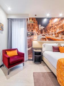 a bedroom with a bed and a chair and a window at Hotel Indigo Madrid - Gran Vía by IHG in Madrid