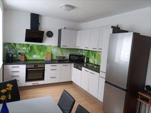a kitchen with white cabinets and a refrigerator at Apartment E2 - Gut ausgestattete 3-Zimmerwohnung 64 qm, für 1-3 Personen 1 DZ 1EZ in Grafenwöhr