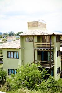 un bâtiment vert avec un toit en haut dans l'établissement Pousada Praia Verde, à Barra de Ibiraquera