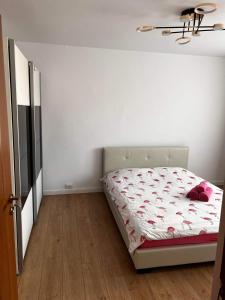 una camera con un letto in una stanza con pareti bianche di Garsoniera Flamingo Garii 4 a Braşov