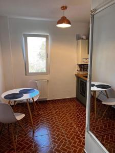 una habitación con 2 mesas y sillas y una cocina en Garsoniera Flamingo Garii 4 en Braşov