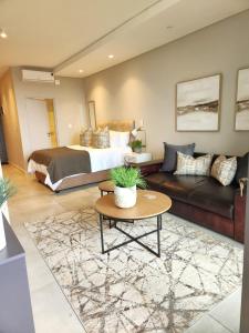 um quarto com uma cama, um sofá e uma mesa em Zimbali Lakes Boulevard Suites, Unit148 em Ballito