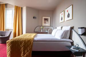 ein Hotelzimmer mit einem Bett und einem Stuhl in der Unterkunft Grand Hôtel Bristol in Colmar