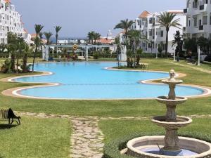 une fontaine au milieu d'un parc avec des bâtiments dans l'établissement Mi Casa Jardins de Cabo Negro, à Cabo Negro