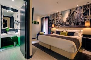 a bedroom with a large bed and a bathroom at Hotel Indigo Madrid - Gran Vía by IHG in Madrid