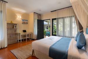 een slaapkamer met een bed, een bureau en een raam bij Sea&Sky Beach Resort in Mae Nam