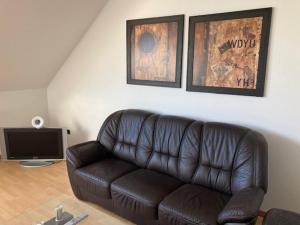 sala de estar con sofá de cuero y TV en Schone Monteure Wohnung in Duisburg Meiderich 47137 en Duisburg