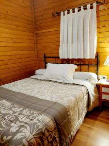 アロヨ・フリオにあるCabañas los Pinos Arroyo Frioの窓付きの木造の部屋のベッド1台