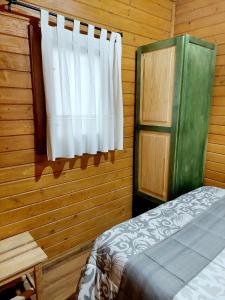 1 dormitorio con cama y ventana en Cabañas los Pinos Arroyo Frio, en Arroyo Frío