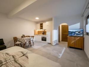 a living room with a dining table and a kitchen at Appartement Alpenlöwe in Kirchberg in Tirol