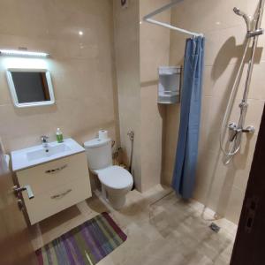 La salle de bains est pourvue de toilettes, d'un lavabo et d'une douche. dans l'établissement Appartement Résidence fermée, à Casablanca