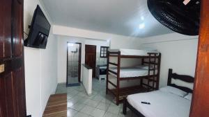 a room with two bunk beds and a bathroom at Quitinete família standard 202 in Cabo Frio