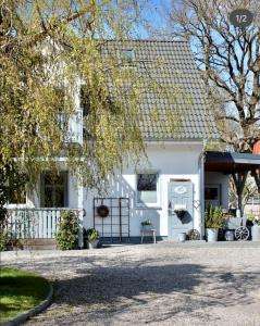 a white house with a tree in front of it at Haus Strandleben in Hohwacht