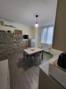 a dining room with a table and a stone wall at Puppo Apartments in Corniglia