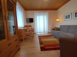 ein Wohnzimmer mit einer Couch und einem Tisch in der Unterkunft Seeblick-Appartements Ossiach in Ossiach