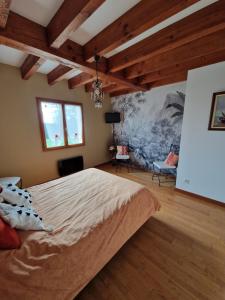 Serres-GastonにあるGrande maison familialeの大きなベッド付きのベッドルーム1室、壁に絵画が飾られています。