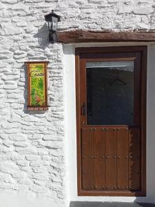 un edificio con una puerta de madera y una ventana en La Casita, en Capileira