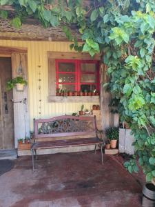 a bench sitting on a porch with a window at Quindio in Barra del Chuy