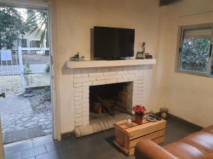 sala de estar con chimenea y TV de pantalla plana en Casa acogedora y funcional, en Atlántida