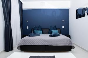 a bedroom with blue walls and a bed with blue pillows at Vladys Vienna Apartments in Vienna