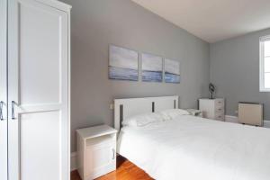 ein weißes Schlafzimmer mit einem großen Bett und einem Fenster in der Unterkunft Céntrico Ático frente al Mar in Vigo