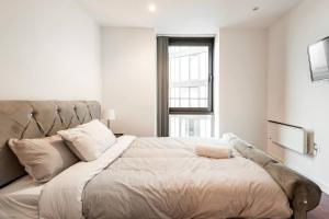 ein Schlafzimmer mit einem großen Bett mit einem großen Fenster in der Unterkunft Lovely Sheffield City Centre 2 Bedroom Apartment in Sheffield