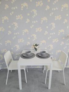 a dining room table with two cups and chairs at Oaza apartmani 1 in Senta