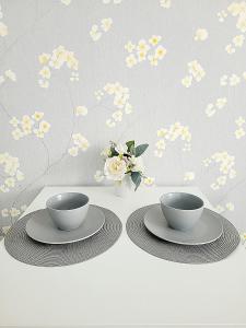 two cups and plates on a table with flowers at Oaza apartmani 1 in Senta