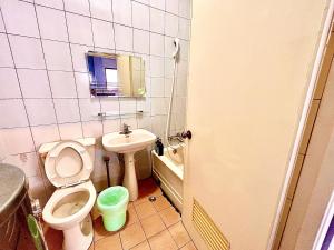 a small bathroom with a toilet and a sink at Time Capsule in Taitung City