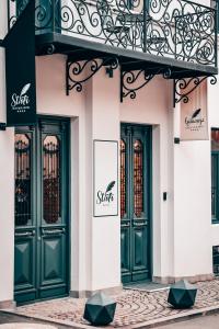 a building with green doors and a balcony at STROFI Boutique Hotel in Tbilisi City
