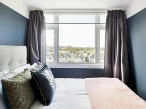 a bedroom with a bed and a large window at Pass the Keys Eton Penthouse with Amazing Castle River Views in Windsor