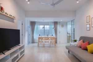 a living room with a couch and a dining room table at Ther house Banchang in Ban Chang