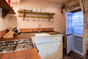 a kitchen with a sink and a stove at Orchard Cottage cosy rustic comfort just across the fields to a great Pub 