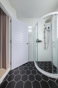 a bathroom with a shower with a glass door at Ther house Banchang in Ban Chang