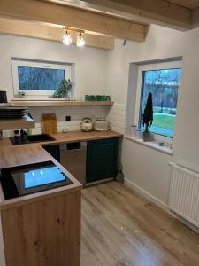 a large kitchen with a counter and a window at Domki Pod Brzozami Ustroń 2 in Ustroń