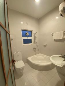 a bathroom with a toilet and a tub and a sink at Aryaf hostel in Nizwa