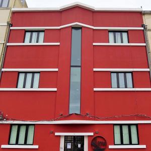 a red building with white windows at The Bridge in Lisbon