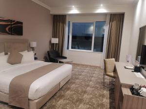 Uma cama ou camas num quarto em Gloria Hotel & Suites Doha