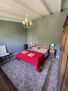 1 dormitorio con 1 cama con manta roja en Casitas El Lago en Carhué