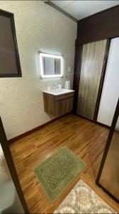 a bathroom with a sink and a wooden floor at Casita Don Eliber in Fortuna