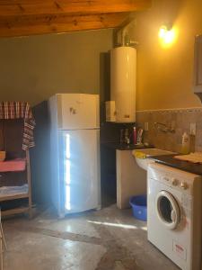 a kitchen with a refrigerator and a washing machine at Casitas El Lago in Carhué