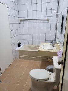 a bathroom with a toilet and a sink and a tub at Time Capsule in Taitung City
