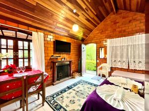 a room with a bed and a fireplace at Emy Pousada in Monte Verde