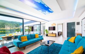 una sala de estar con sofás azules y una mesa. en Dreamy Villa with Private Pool and Jacuzzi in Kas, en Sarıbelen