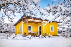 a yellow house with snow on the ground at Ferienhaus Schlagerbauer Biohof in Salzburg