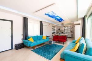 a living room with blue couches and a table at Dreamy Villa with Private Pool and Jacuzzi in Kas in Sarıbelen