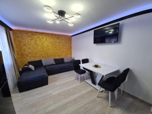 ein Wohnzimmer mit einem Sofa und einem Tisch in der Unterkunft Diamonds House 2 in Lupeni