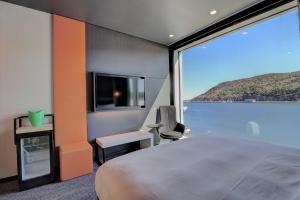 a bedroom with a large bed and a large window at Alt Hotel St. John's in St. John's